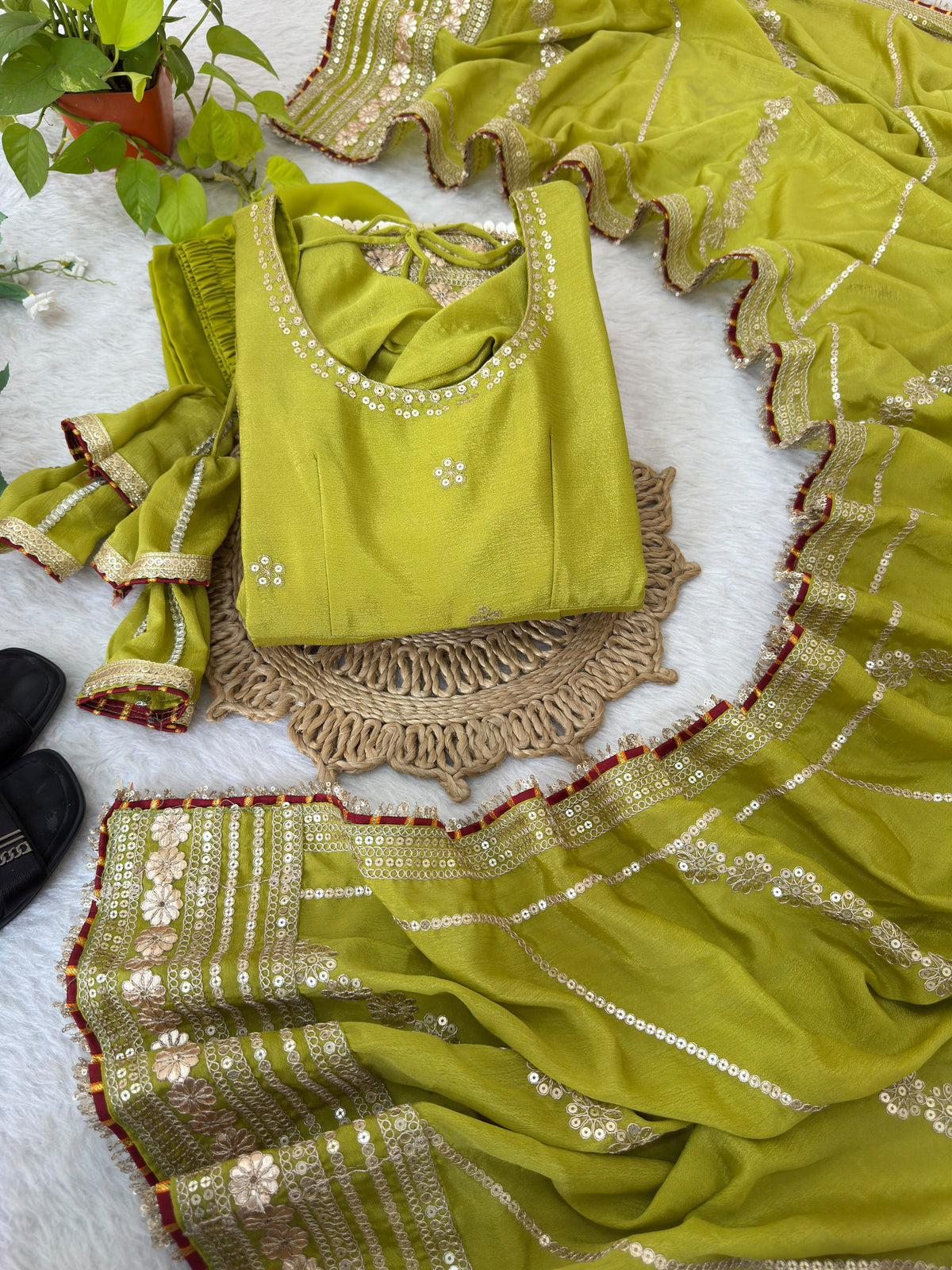 Olive Green Chinon Silk Anarkali Gown Set - flat lay complete set overview showing Anarkali gown with gold sequence floral hem border, matching olive green ruffle dupatta with gold embroidery, crepe straight pant and scrunchie hair accessory