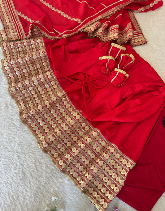 Bridal Red Chinon Silk Anarkali Gown Set - flat lay product close-up showing gown top half with round scoop neck, scattered gold butti body, full sleeves with gold lace cuff trim, tie-back latkan tassel at nape, and matching red dupatta with diagonal gold sequence stripe work
