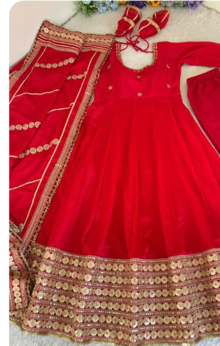 Bridal Red Chinon Silk Anarkali Gown - flat lay close-up detail shot showing spectacular wide dense multi-row gold sequence floral daisy embroidery hem border with alternating gold sequence stripe rows and maroon velvet ribbon edge trim on rich bridal red chinon silk