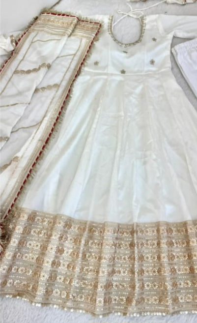 Ivory White Chinon Silk Anarkali Gown Set - flat lay close-up product shot showing full length gown with coding embroidery body, wide dense gold silver sequence floral daisy embroidery hem border with pearl accents, and ivory chinon silk dupatta with heavy gold sequence lace pallu border
