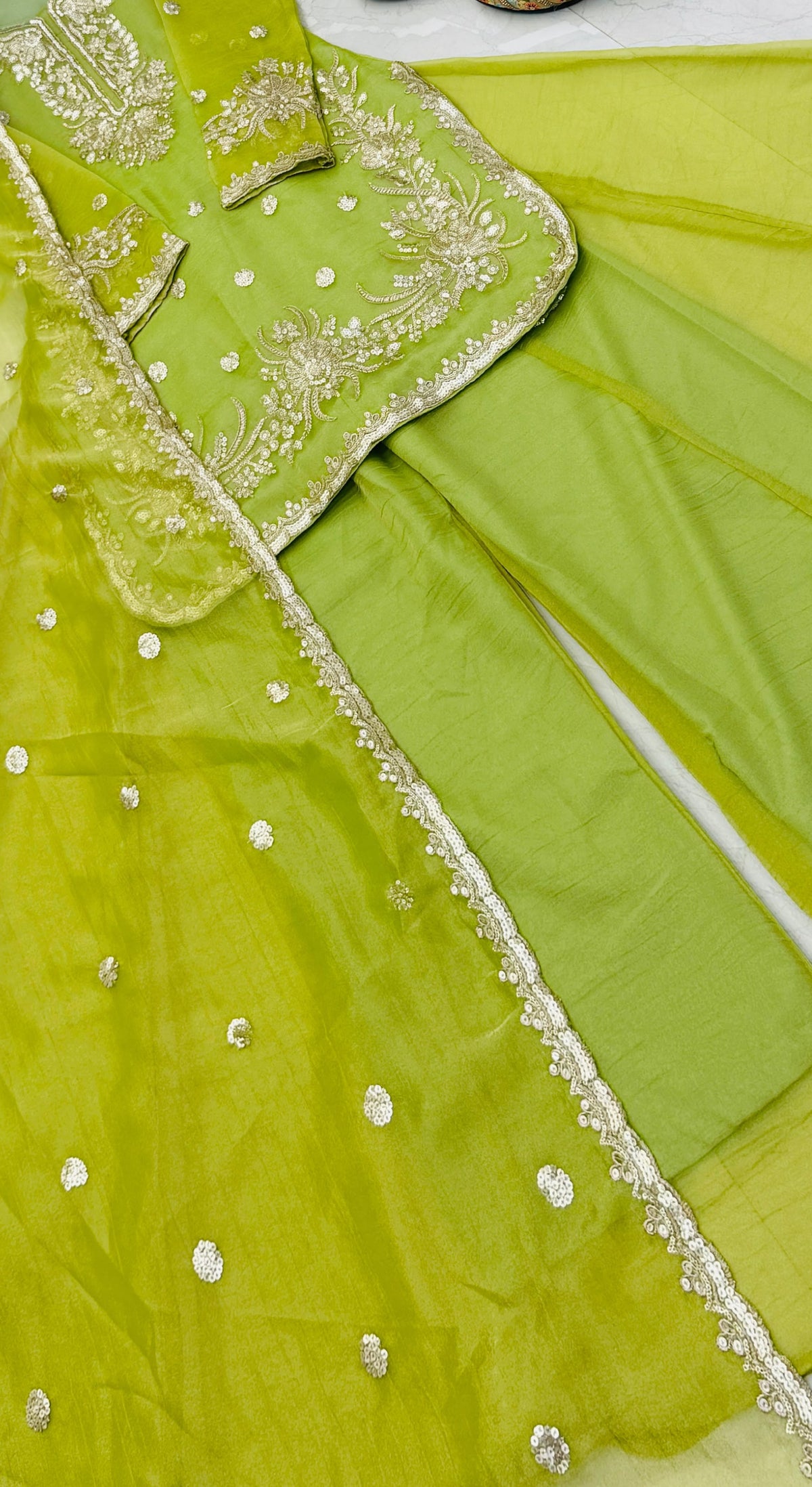 Lime Green Shalsa Crash Sharara Set - flat lay close-up showing top with dense gold zardozi floral scrollwork yoke embroidery, scattered gold silver sequence oval butti body work, dramatic scalloped gold sequence embroidery hem border, and dupatta with scattered sequence butti and scalloped gold sequence lace border