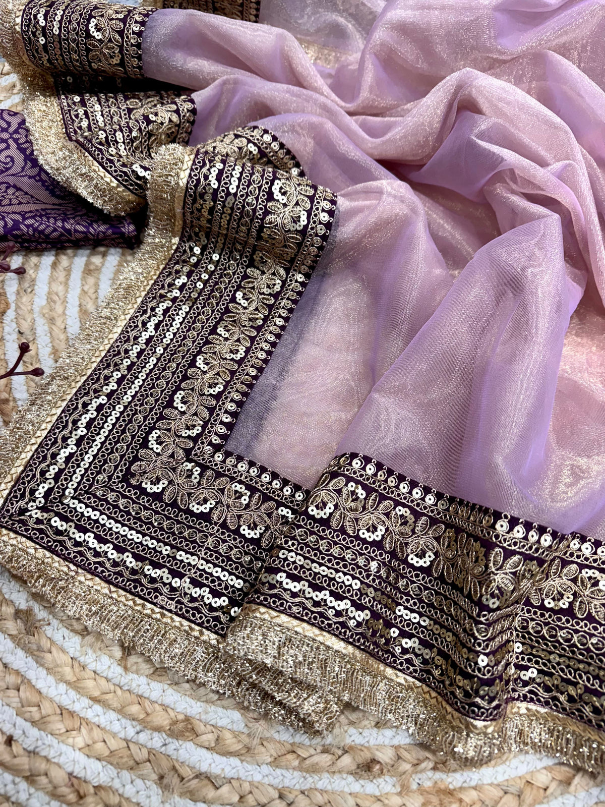 Dusty Mauve Soft Twill Net Saree - outdoor desert hillside full length wide-shot model dancing pose showing entire saree drape in motion with sheer dusty mauve net body, triple-tier gold sequence dori embroidery scallop lace border at hem and pallu billowing and deep aubergine jacquard silk blouse against expansive golden hour landscape
