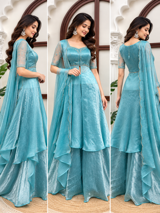Aqua Blue Fendy Crush Front Slit Anarkali Palazzo Set - heritage interior full length back view standing model showing tassel tie back closure on anarkali blouse, sheer net sleeves with floral silver sequence embroidery clusters, back of double-tier ruffle cascade hem and dupatta with scallop cutwork thread border