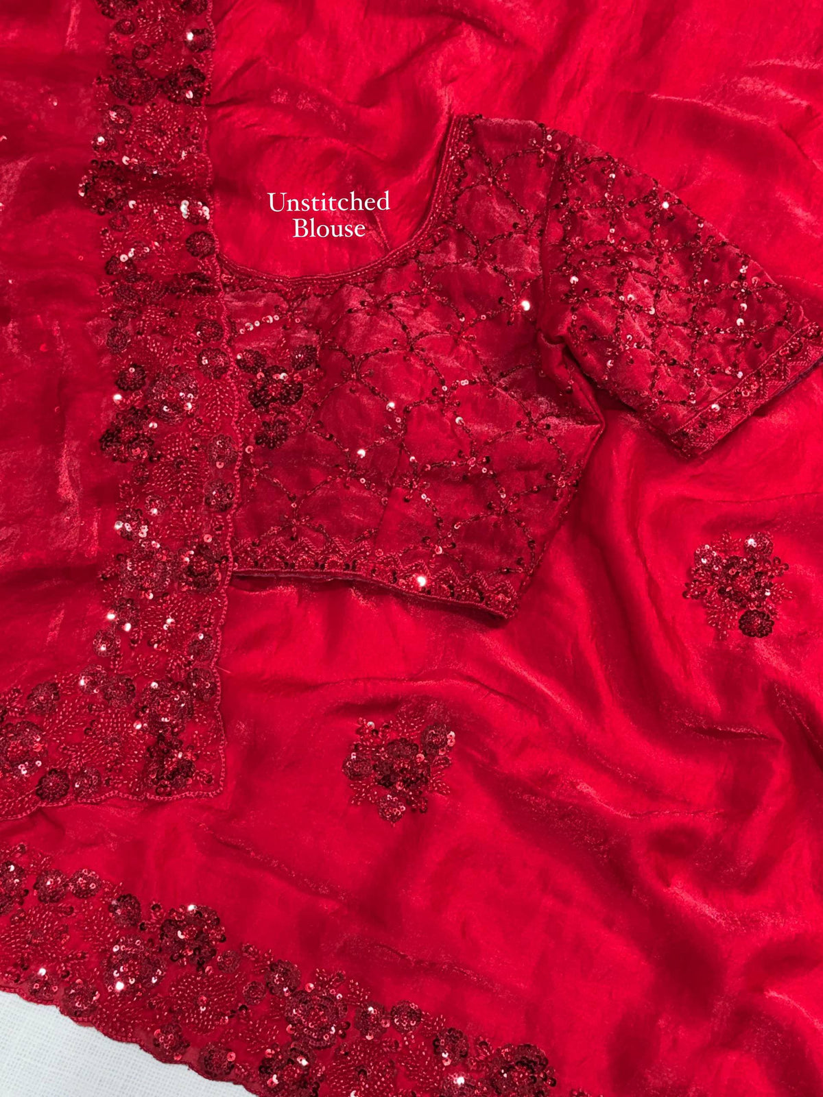 Crimson Red Fandy Satin Saree - extreme close-up macro detail of saree border showing dense 3D raised red sequence floral bouquet cluster embroidery on scallop cutwork border pattern, diamond lattice cord sequence coverage on saree body and individual raised floral butti clearly showing three-dimensional projection from satin surface