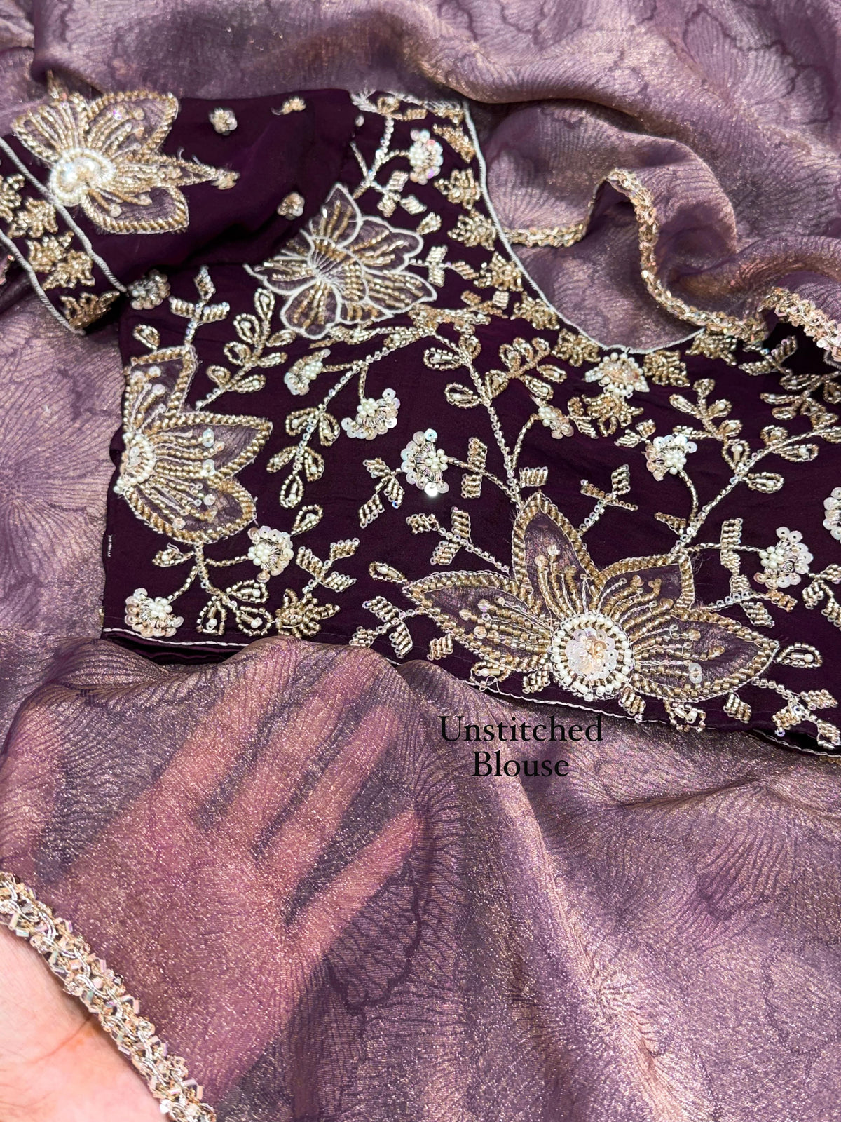 Close-up of deep plum unstitched NC moss blouse fabric with floral applique and beads handwork against lustrous dusty mauve jacquard saree fabric.