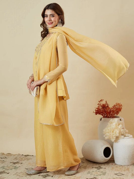 Sunshine Yellow Crunchy Silk Kurta Palazzo Set - studio full length back standing model view showing complete set back silhouette with matching crunchy silk dupatta draped over shoulder showing thin gold lace trim border, wide-leg palazzo and full sleeves with scalloped ruffle cuff frill