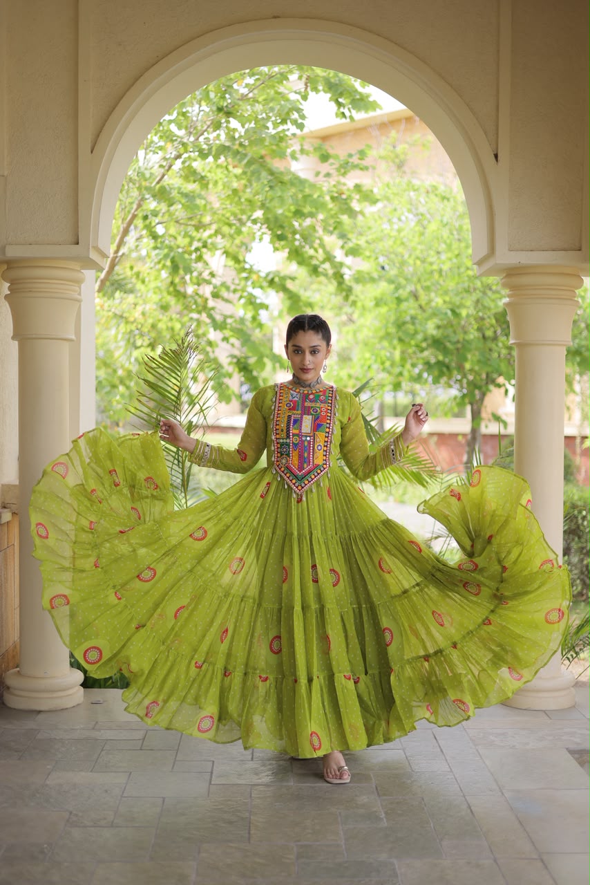 Lime Green Bandhani Faux Georgette Gown - outdoor haveli close-up portrait showing multicolour Kutchi patchwork yoke with real mirror work, sequin embroidery and cowrie shell tassels on vibrant lime green bandhani georgette with full sleeves and silver gota lace cuff border with mirror work
