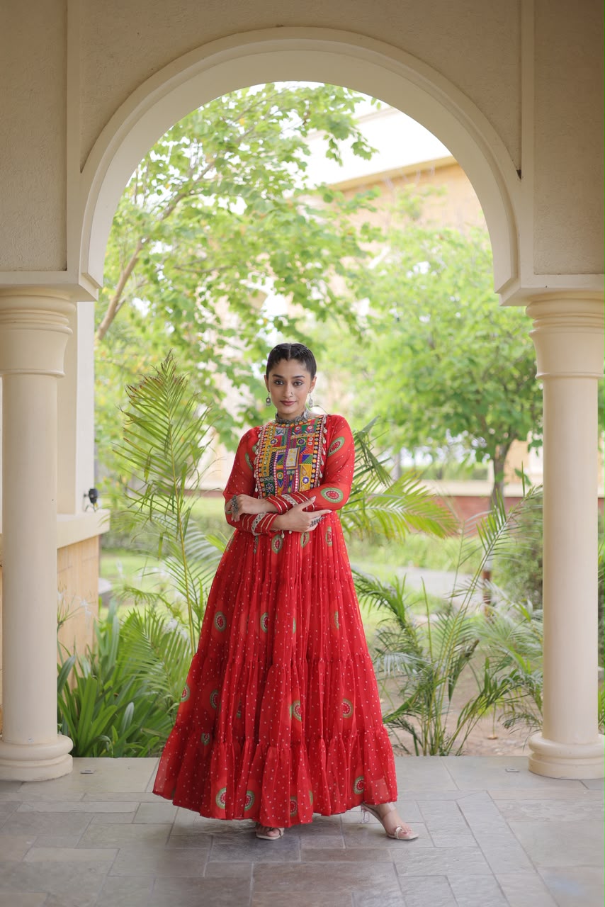 Red Bandhani Faux Georgette Gown with Kutchi Patchwork Yoke - close-up portrait showing multicolour Kutchi patchwork yoke with real mirror work, sequin embroidery and cowrie shell tassels on vibrant red bandhani georgette with full sleeves and gold gota lace cuff border