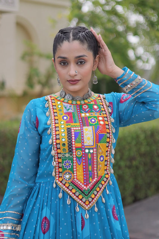 Turquoise Bandhani Faux Georgette Gown - close-up portrait showing multicolour Kutchi patchwork yoke with real mirror work, sequin embroidery and cowrie shell tassels; silver gota lace cuff border with mirror work detail on full sleeve