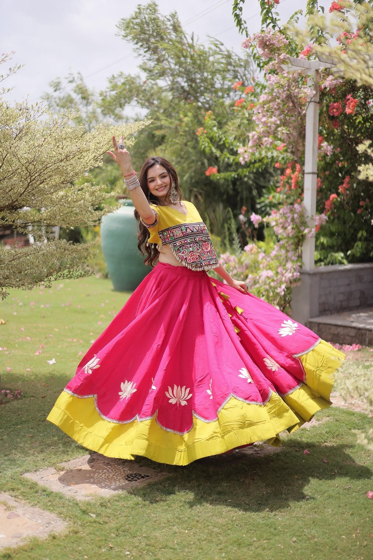 Fully stitched hot pink Roman lehenga with lotus gota motifs, scalloped mirror lace edge and wide yellow hem, paired with yellow Kutchi Gamthi embroidered choli.