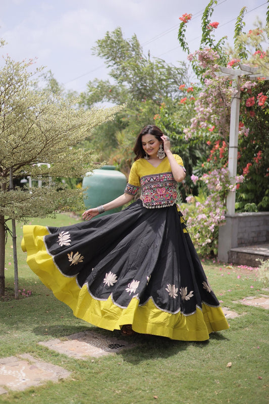 Fully stitched black Roman lehenga with lotus gota motifs, scalloped mirror lace edge and broad yellow hem, paired with a yellow Kutchi Gamthi embroidered choli.